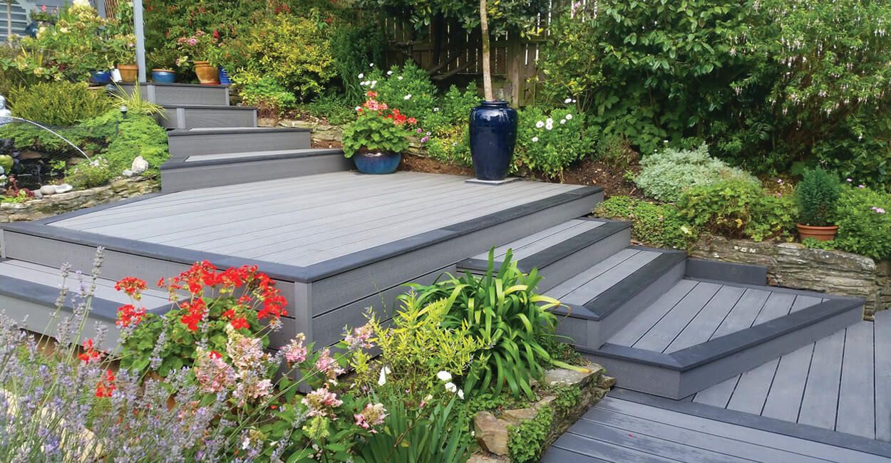 Neutral grey decking with flowers and climbing plants