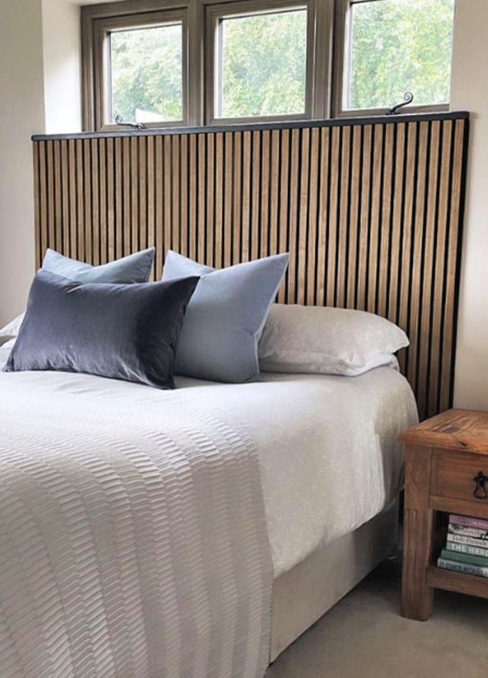 Headboard behind a bed made out of wooden horizontal slats