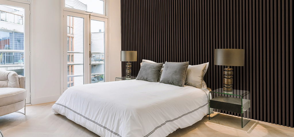 A double bed with dark brown wooden panels