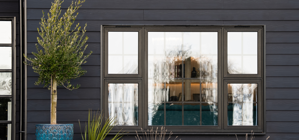 Close-up of a window framed with Cladco black fibre cement wall cladding.