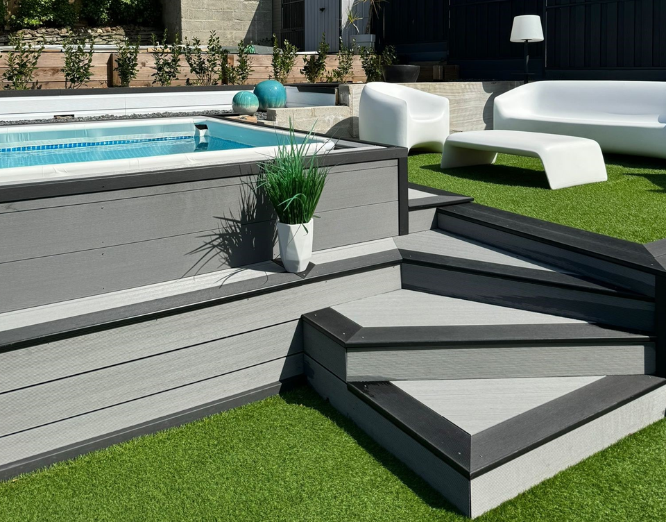 Raised composite decking board pool surround with steps.