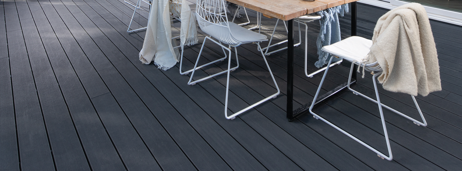 Outdoor dining table and chairs on composite decking.